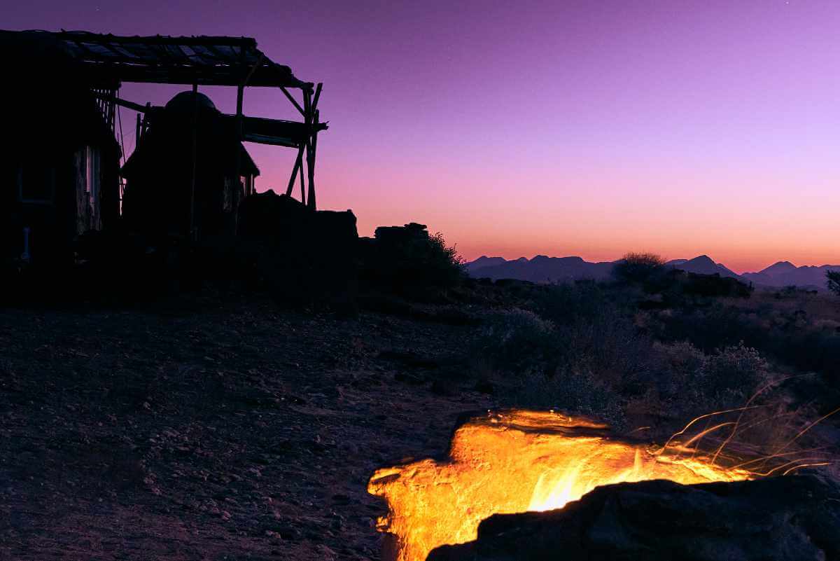 A fire burns in the campsite fire pit, the ultimate way to spend a night under an African sky.
